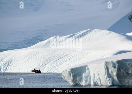 Lumière de l'après-midi, les touristes dans un Zodiac observent le paysage autour de la baie Marguerite, au sud du cercle antarctique. Antarctique, Banque D'Images