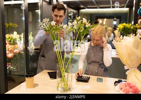 Deux fleuristes expérimentés assemblant un bouquet de fleurs fraîches, concept pour les petites entreprises et les entrepreneurs individuels Banque D'Images