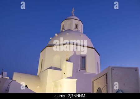 Vue sur une église grecque typique mais magnifique illuminée à Fira Santorini Banque D'Images