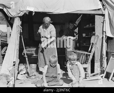 Femme âgée avec trois de ses vingt-deux petits-enfants, camp de migration du comté de Kern, Californie. [Signe : 'avertissement ! Pas de visiteurs. Par ordre de l'agent de santé]. Banque D'Images