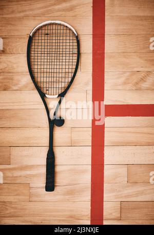 Aussi résistant que n'importe quel joueur de squash le mérite. Photo d'une raquette de squash sur le sol d'un court de squash. Banque D'Images