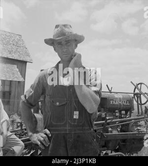 Ancien agriculteur locataire d'une grande ferme de coton maintenant un conducteur de tracteur pour un dollar par jour sur la même ferme. Comté de Bell, Texas. Banque D'Images