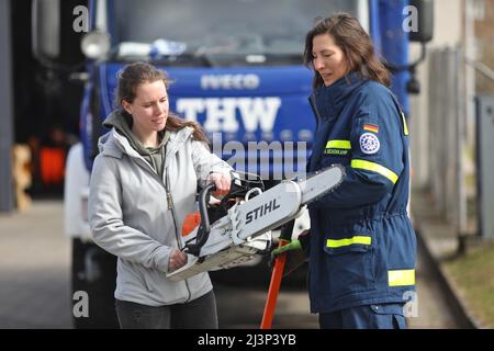 Rostock, Allemagne. 09th avril 2022. Alexandra Beckenkamp (r) de la branche Wismar de la THW explique une scie de sauvetage à Sophia Kossow (l) de Rostock. L'Agence de secours technique de Rostock représente symboliquement diverses activités qui peuvent être essayées par des écolières à l'échelle nationale lors de la Journée des filles le 28 avril. Credit: Danny Gohlke/dpa/Alay Live News Banque D'Images