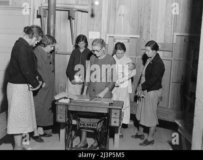 La rencontre du Club des mères dans le camp d'Arvin pour les travailleurs migrants, dans le camp de l'Administration de la sécurité agricole (FSA) en Californie, s'ouvre avec la prière. [Note Singer machine à coudre à pédales]. Banque D'Images