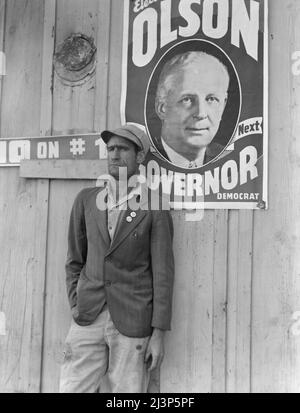 Travailleur migratoire sur le terrain, chef de la grève du coton d'octobre 1938, qui a eu lieu juste avant les élections. Kern County, Californie. [L'affiche représente Culbert Olson, en vue de son élection au poste de gouverneur de la Californie]. Banque D'Images