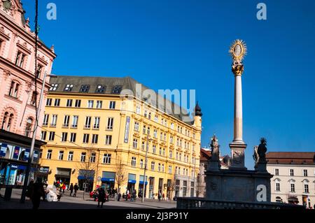 La colonne de la peste de la Vierge Marie Immaculée sur la place de la liberté à Brno, République tchèque et Newton College. Banque D'Images