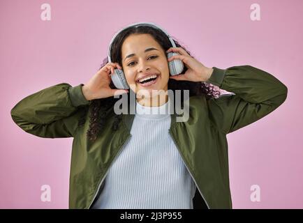 De bons battements et de bonnes vibrations sont tout ce dont j'ai besoin. Photo d'une jeune femme attrayante debout sur fond rose dans le studio et écoutant de la musique Banque D'Images