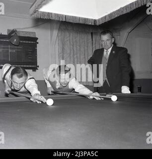 1960, historique, snooker Match, deux joueurs de snooker masculins en chemise et cravates et gilets, à la table de snooker qui s'inscrit au pot a ball, sous la surveillance de l'arbitre, Oxford, Angleterre, Royaume-Uni. Banque D'Images