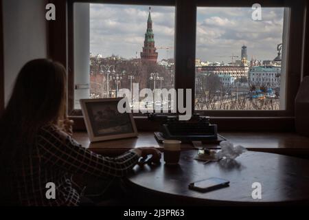 Moscou, Russie. 9th avril 2022. Une fille boit un café dans la maison de Pashkov avec vue sur le Kremlin de Moscou, Russie Banque D'Images