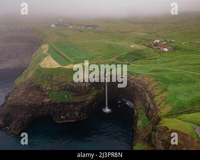 Belle vue aérienne de la cascade de Gasadalur et du village et des paysages des îles Féroé Banque D'Images