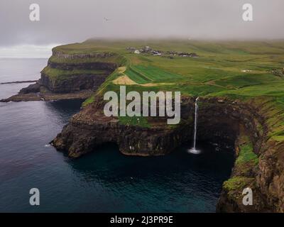 Belle vue aérienne de la cascade de Gasadalur et du village et des paysages des îles Féroé Banque D'Images