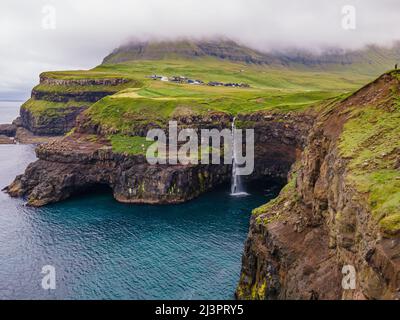 Belle vue aérienne de la cascade de Gasadalur et du village et des paysages des îles Féroé Banque D'Images