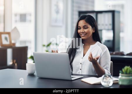 Travailler avec une webcam. Photo d'une jeune femme d'affaires effectuant un appel vidéo sur un ordinateur portable dans un bureau. Banque D'Images
