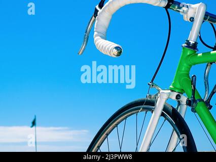 vélo de course vert avec le guidon blanc sur fond bleu ciel Banque D'Images