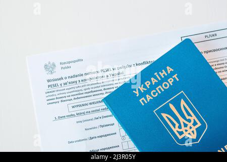 Document PESEL, passeport ukrainien et stylo sur fond de table blanc. Banque D'Images