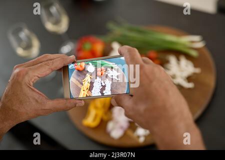 Cette image doit être partagée en ligne. Photo d'un homme prenant une photo des ingrédients avec son téléphone. Banque D'Images