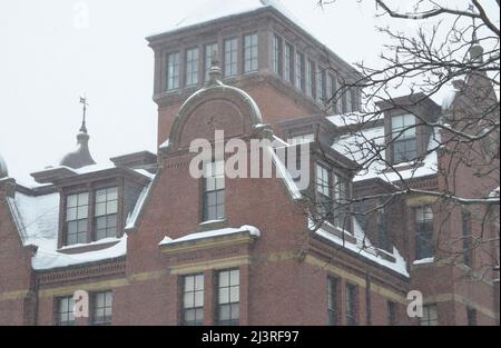 Scène hivernale enneigée du campus de l'Université Harvard à Cambridge, Massachusetts, avec des bâtiments architecturaux historiques pendant une tempête de neige hivernale. Banque D'Images