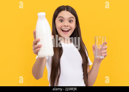 l'enfant émerveillé offre des produits de boisson laitière. jeune fille va boire du lait. Banque D'Images