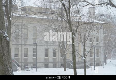 Scène hivernale enneigée du campus de l'Université Harvard à Cambridge, Massachusetts, avec des bâtiments architecturaux historiques pendant une tempête de neige hivernale. Banque D'Images