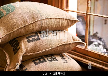 L'essence de l'industrie du café. Prise d'un sac de toile rempli de grains de café non transformés. Banque D'Images