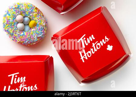 Calgary, Alberta, Canada. 9 avril 2022. Un donut de Pâques Tim Hortons avec des récipients de sandwichs alimentaires sur fond blanc Banque D'Images