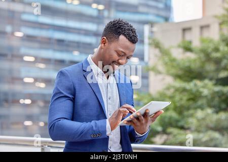 HES a obtenu toutes les connexions. Photo d'un jeune homme d'affaires utilisant une tablette numérique sur fond urbain. Banque D'Images