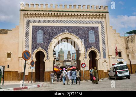 Fes, Maroc. Les jeunes femmes en passant par la porte Bab Boujeloud, entrée à Fès El-Bali, la vieille ville. Le minaret de la Medersa Bou Inania est dans le Banque D'Images