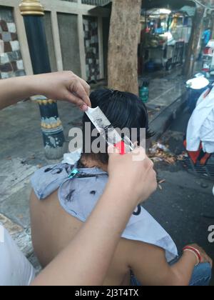 Bangkok, Thaïlande - janvier 22th 2022 : coiffeur de rue coiffant un homme à l'aide de la tondeuse à cheveux Banque D'Images