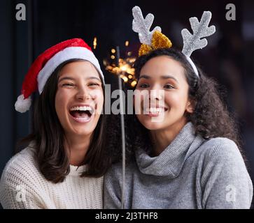 Fêtez Noël avec les bonnes personnes. Photo de deux meilleurs amis se tenant ensemble et tenant un peu plus de temps pour célébrer Noël. Banque D'Images