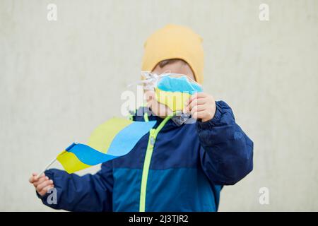 Un petit garçon patriotique détient un drapeau ukrainien et un biscuit symbolique. Tenez-vous avec l'Ukraine. Soutenir l'Ukraine. Arrêter le concept d'agression russe. Arrêter la guerre Banque D'Images