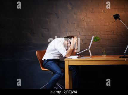 Ces jours-ci ont été bien trop longs Photo d'un homme d'affaires qui a l'air épuisé après une longue journée au bureau. Banque D'Images