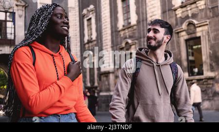 Couple multiracial de jeunes touristes marchant dans le centre-ville historique Banque D'Images