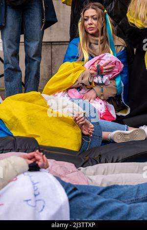 Des manifestants qui mènent une mort-dans, faisant référence aux civils ukrainiens tués dans des villes comme Bucha pendant la guerre avec la Russie. « Bébé » est mort de sang avec « autre » Banque D'Images