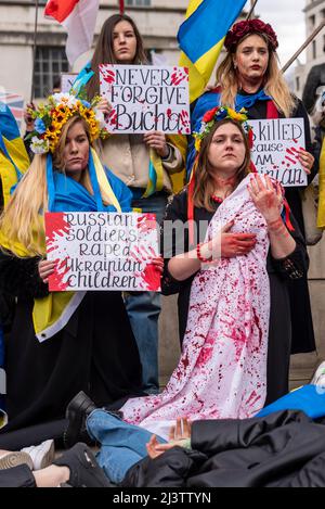 Des manifestants qui mènent une mort-dans, faisant référence aux civils ukrainiens tués dans des villes comme Bucha pendant la guerre avec la Russie. Femelles sangsuées Banque D'Images