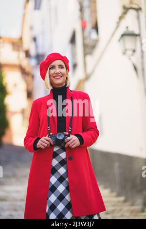 Souriante touriste féminine avec appareil photo debout sur les escaliers de la rue de la ville Banque D'Images