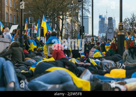 Des centaines de personnes se trouvent sur le terrain pour protester contre l'invasion russe alors qu'elles sont entourées de drapeaux ukrainiens. Arrêter la guerre. Pro-ukrainien Banque D'Images
