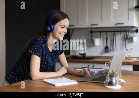 Une jeune femme dans un casque utilise un ordinateur portable, des informations de navigation sur le Web Banque D'Images