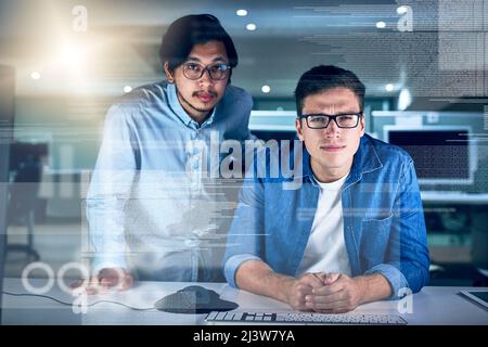 Ils sont les spécialistes dans ce domaine de travail. Portrait de deux jeunes programmeurs masculins travaillant sur un ordinateur ensemble dans le bureau la nuit. Banque D'Images