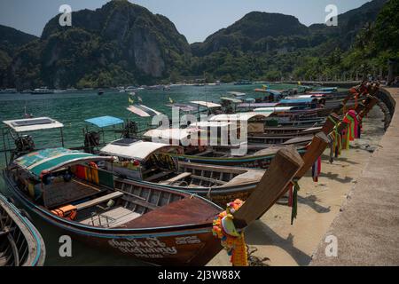 Krabi, Thaïlande. 9th avril 2021. Une rangée de bateaux à longue queue attendant sur la plage de sable de l'île de Phi Phi Don. Connue depuis longtemps comme une destination de voyage internationale populaire, la Thaïlande a subi des dommages massifs à son industrie touristique en raison des restrictions de voyage imposées par la pandémie. Le Krabi, une province célèbre pour ses falaises calcaires déchiquetées, a été pratiquement déserté pendant la plus grande partie de 2020 et 2021. L'assouplissement des restrictions d'entrée par le gouvernement thaïlandais a encouragé les visiteurs à commencer à revenir. (Credit image: © Adryel Talamantes/ZUMA Press Wire) Banque D'Images