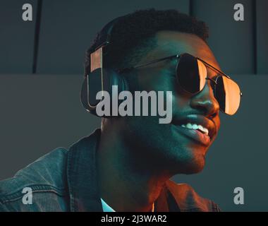 Je suis toujours d'humeur, une bonne humeur. Photo en studio d'un homme portant un casque et des lunettes de soleil. Banque D'Images