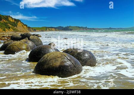 Close up de Moeraki Boulders sphérique de pélites sur la plage baignée par les vagues déferlantes de la mer, Koekohe plage, plage de galets, Nouvelle-Zélande Banque D'Images