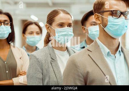Des hommes d'affaires multinationaux portant des masques protecteurs Banque D'Images
