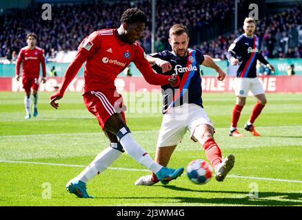 Kiel, Allemagne. 10th avril 2022. Football: 2nd Bundesliga, Holstein Kiel - Hamburger SV, Matchday 29, stade Holstein. Faride Alidou (l) de Hambourg et Marco Komenda de Kiel se battent pour le ballon. Crédit : Axel Heimken/dpa - REMARQUE IMPORTANTE : Conformément aux exigences de la DFL Deutsche Fußball Liga et de la DFB Deutscher Fußball-Bund, il est interdit d'utiliser ou d'avoir utilisé des photos prises dans le stade et/ou du match sous forme de séquences et/ou de séries de photos de type vidéo./dpa/Alay Live News Banque D'Images