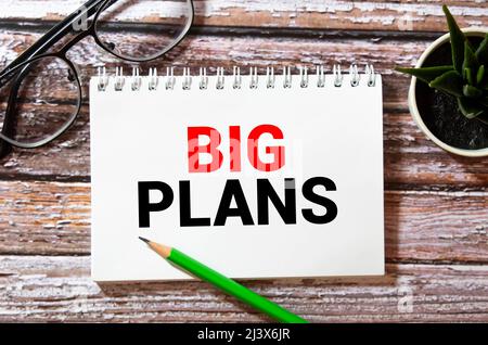 Schéma financier sur grand bloc-notes blanc, livre vert et feuille de papier avec texte GRAND PLAN Banque D'Images