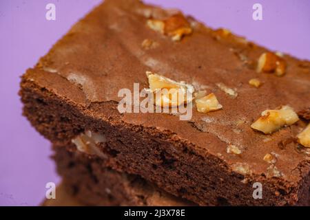 Carrés au chocolat et morceaux de noix de pécan faits maison. Arrière-plan orange. Concept d'alimentation naturelle et saine. Vue en hauteur. Banque D'Images