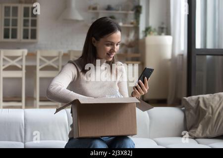 Jeune cliente heureuse femme recevant un achat sur Internet Store Banque D'Images