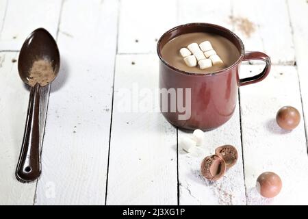 boisson chaude au chocolat dans un mug en émail d'époque sur fond de bois Banque D'Images