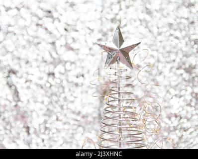 Câblez l'arbre de Noël avec des lumières sur un arrière-plan flou et brillant Banque D'Images
