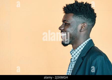Des émotions heureuses. Portrait de rire Africain américain homme posant sur fond jaune, gai jeune Curly Noir homme ayant l'amusement, ayant la bonne humeur, Banque D'Images
