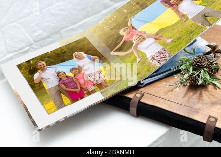 Archives photos de famille enregistrées dans un livre photo aux couleurs vives ; souvenirs d'été éclatants placés dans le livre photo. Famille avec drapeau de l'ukraine Banque D'Images